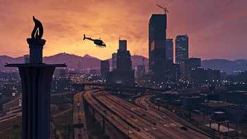 Prédios do centro financeiro de Los Santos ao pôr do sol, com um helicóptero sobre a cidade