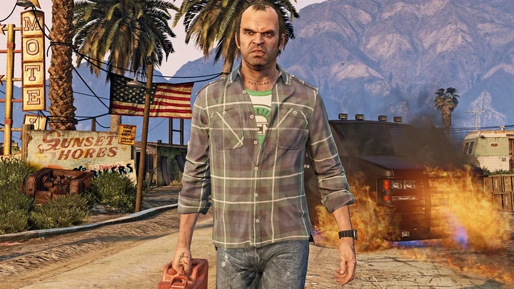 Trevor caminha por Sandy Shores com um galão de gasolina enquanto um carro pega fogo atrás dele